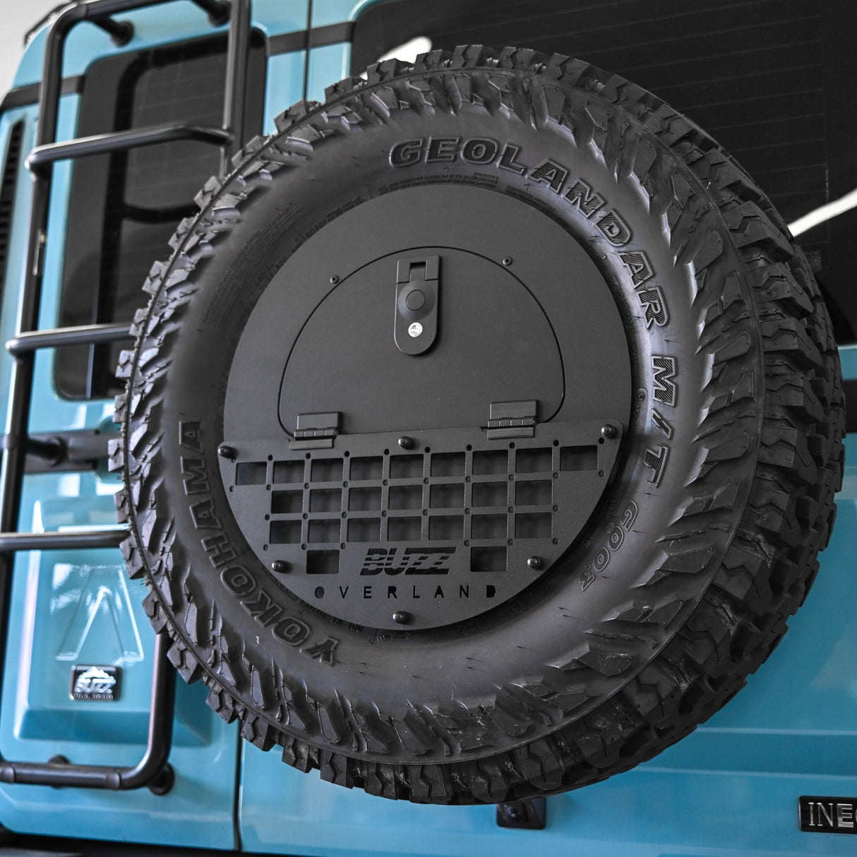 Black molle panel on Buzz Overland Spare Wheel Storage Cubby for INEOS Grenadier, offering versatile accessory mounting for overlanding and off-road customization