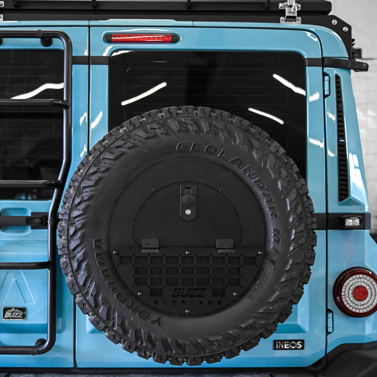 Black molle panel on Buzz Overland Spare Wheel Storage Cubby for INEOS Grenadier, offering versatile accessory mounting for overlanding and off-road customization