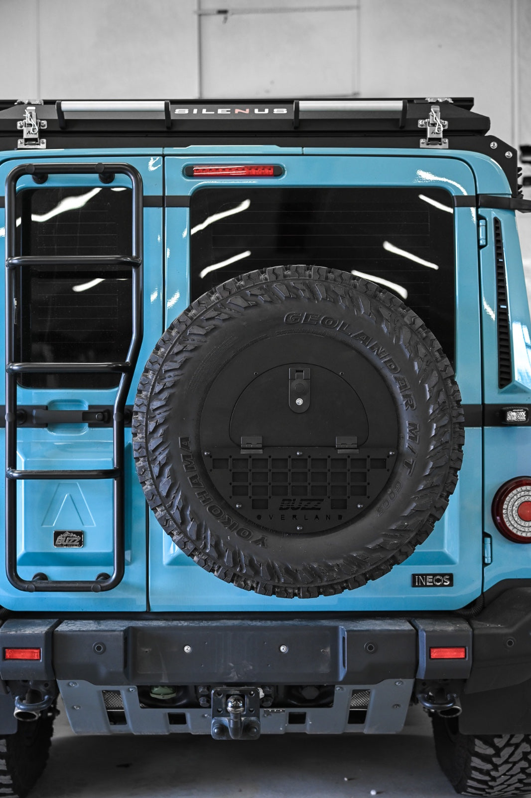 Black molle panel on Buzz Overland Spare Wheel Storage Cubby for INEOS Grenadier, offering versatile accessory mounting for overlanding and off-road customization