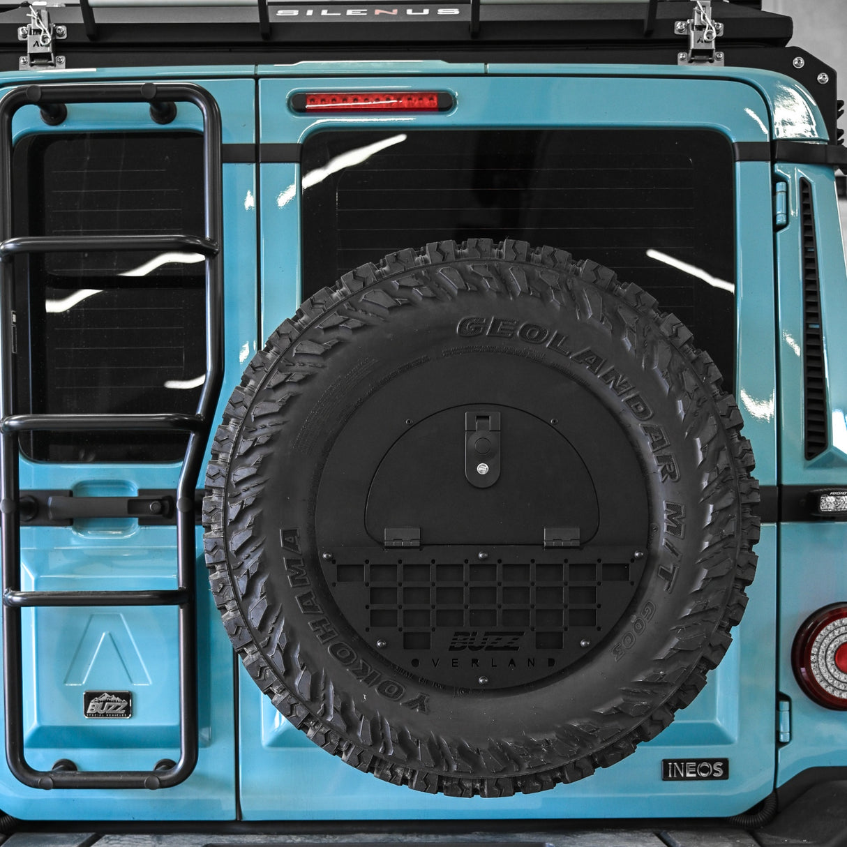 Black molle panel on Buzz Overland Spare Wheel Storage Cubby for INEOS Grenadier, offering versatile accessory mounting for overlanding and off-road customization