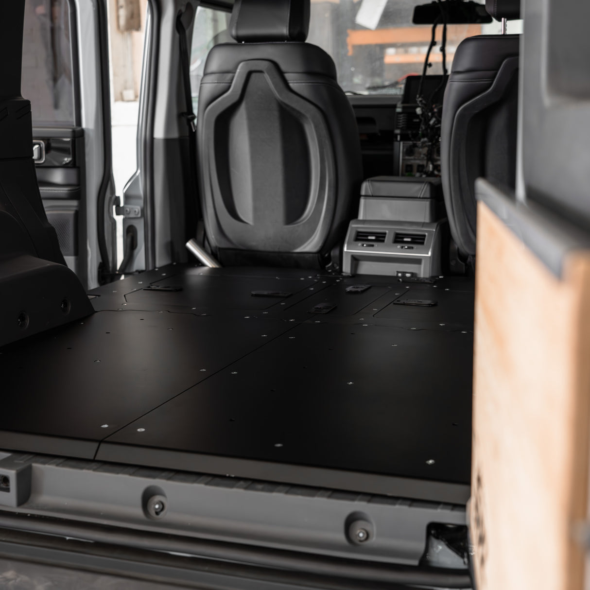 Buzz Overland Buzz Base for INEOS Grenadier, a 36kg 5052 aluminium deck replacing 56kg factory seats, with access hatches for stealth overlanding and roof conversions.
